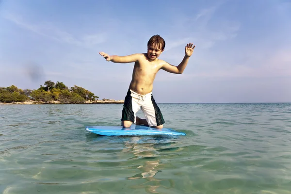 Niño surfeando en el mar — Foto de Stock