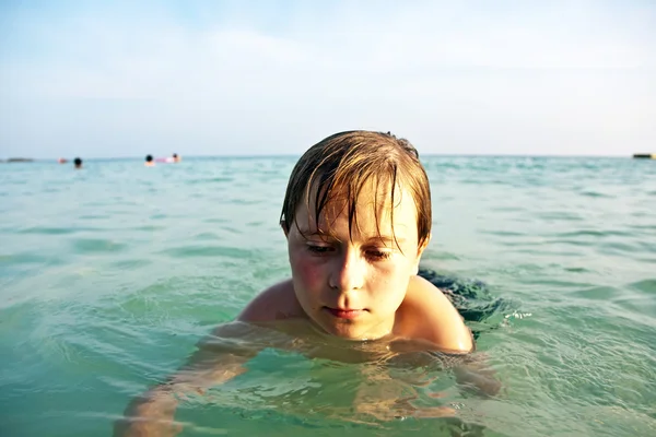 愤怒的小男孩通过明确温暖的海水在步行 — 图库照片