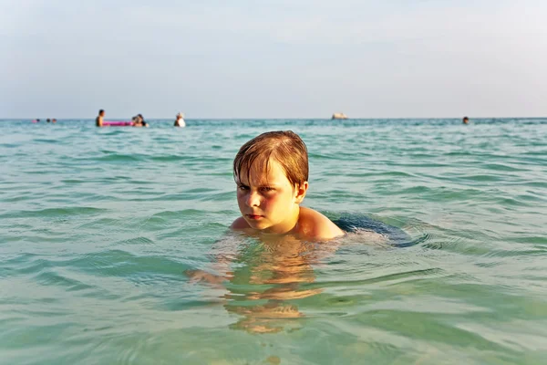 Θυμωμένος αγόρι είναι το περπάτημα μέσα από το σαφές αλμυρού νερού στο ζεστό το — Φωτογραφία Αρχείου