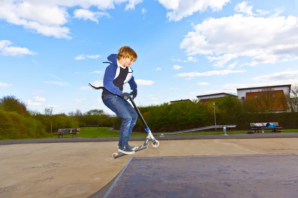 Joven chico tiene divertido ir en el aire con el scooter —  Fotos de Stock