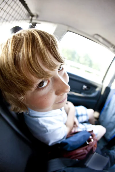 Fond eğleniyor bir arabanın içinde oturan çocuk — Stok fotoğraf