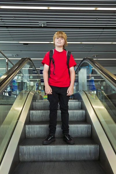 Rapaz numa escada em movimento — Fotografia de Stock