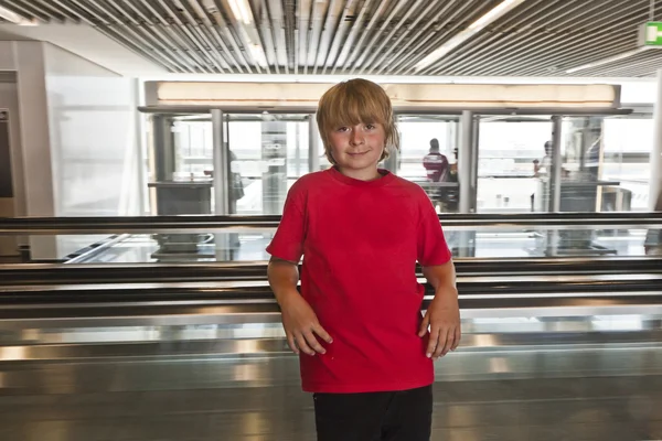 Boy on a moving staircase inside the airport — Stock Photo, Image
