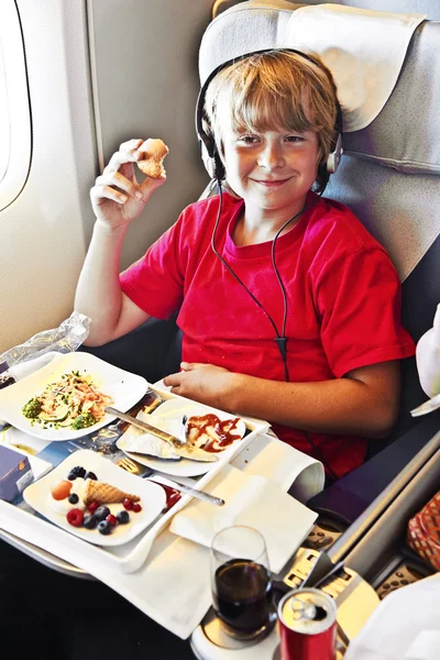 Garoto desfruta do jantar no avião — Fotografia de Stock