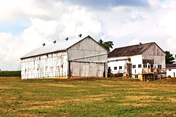 Фермерский дом с полем и силосом — стоковое фото