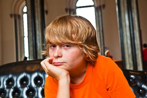 Jongen neemt een rust op een sofa — Stockfoto