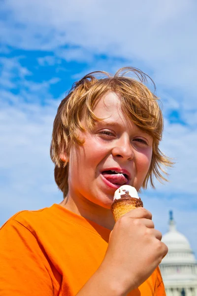 En ung pojke som äter en välsmakande glass — Stockfoto