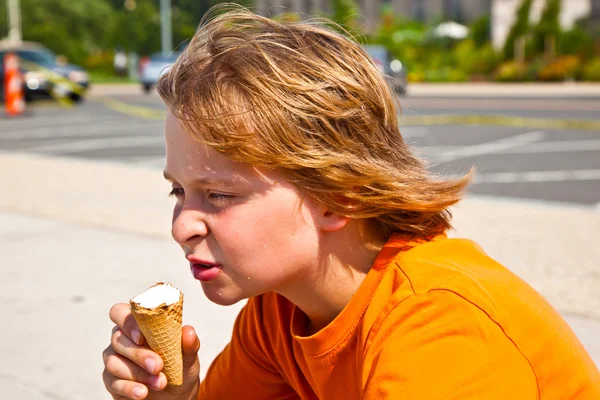 Um menino comendo um saboroso sorvete — Fotografia de Stock