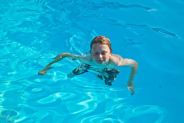 Enfant nage dans la piscine et s'amuse — Photo