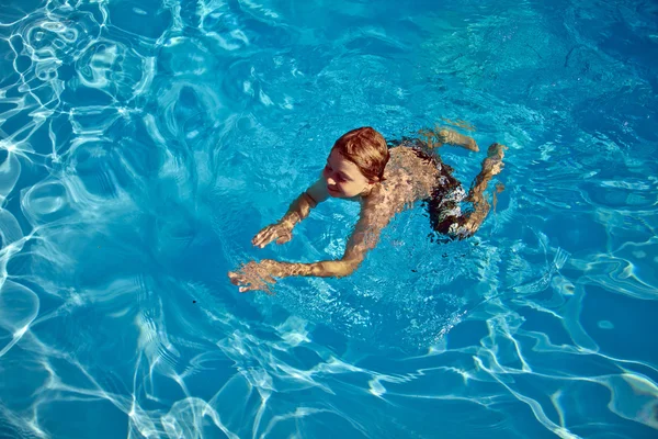 Gyermek úszik a medencében — Stock Fotó
