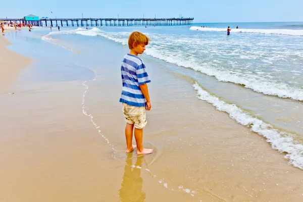 Pojke promenerar på stranden — Stockfoto