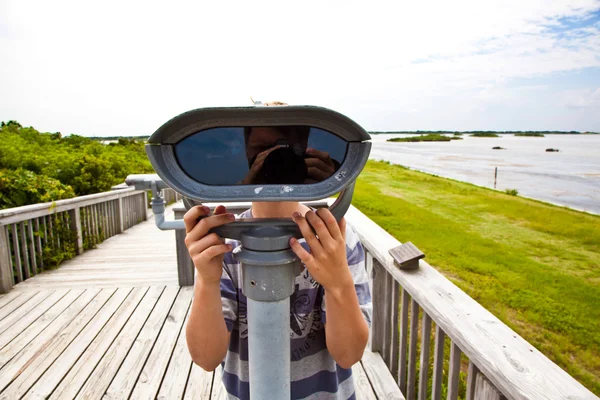 Chico viendo la naturaleza a través de un binocular — Foto de Stock