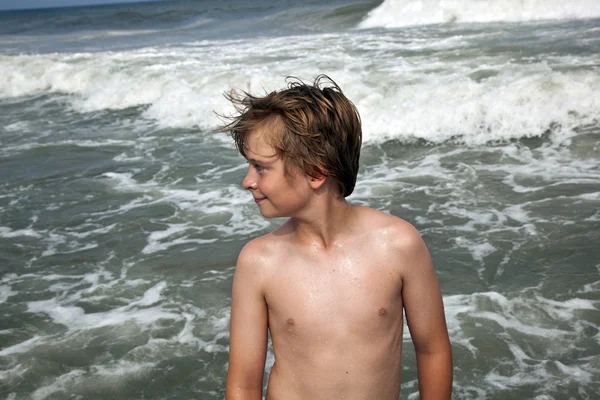 可爱的男孩在风雨如磐的海滩有乐趣 — 图库照片