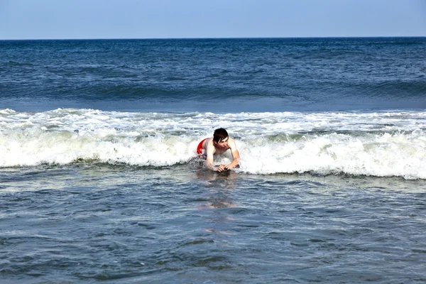 Симпатичный мальчик веселится на бурном пляже — стоковое фото