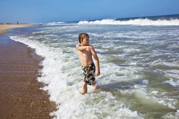 可爱的男孩在风雨如磐的海滩有乐趣 — 图库照片