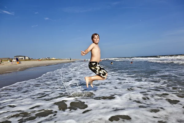Jumping boy goza do belo oceano — Fotografia de Stock