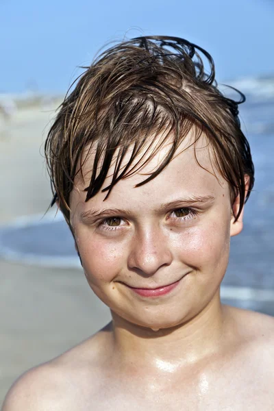 Felice ragazzo con i capelli bagnati in spiaggia — Foto Stock