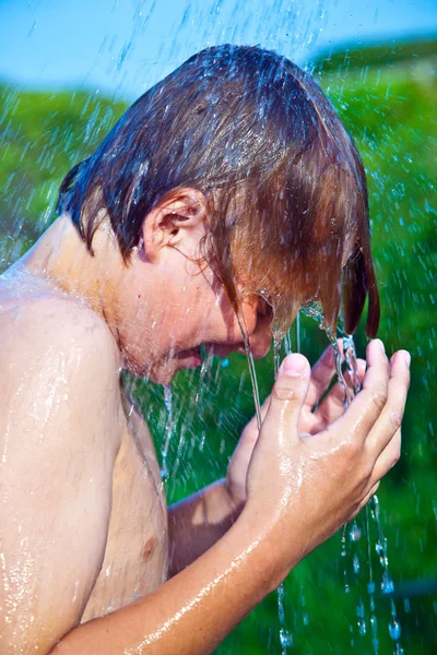 Çocuk, kumsalda duş bulunuyor. — Stok fotoğraf