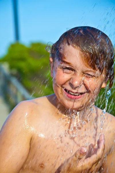 Chłopiec ma prysznic na plaży — Zdjęcie stockowe