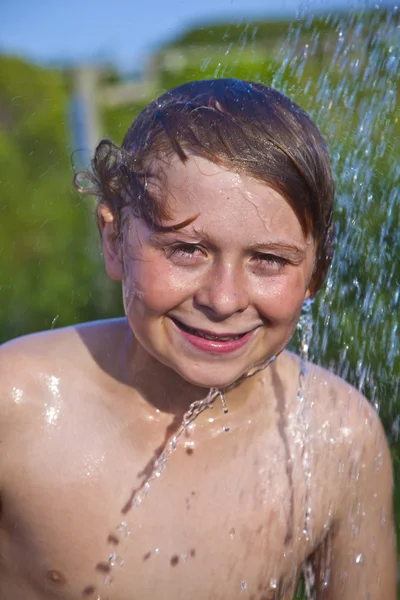 Хлопчик приймає душ на пляжі — стокове фото