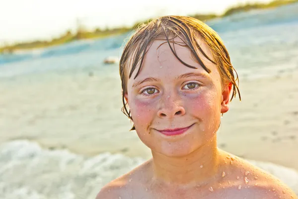 Carino ragazzo ha divertente in il tempestoso spiaggia — Foto Stock