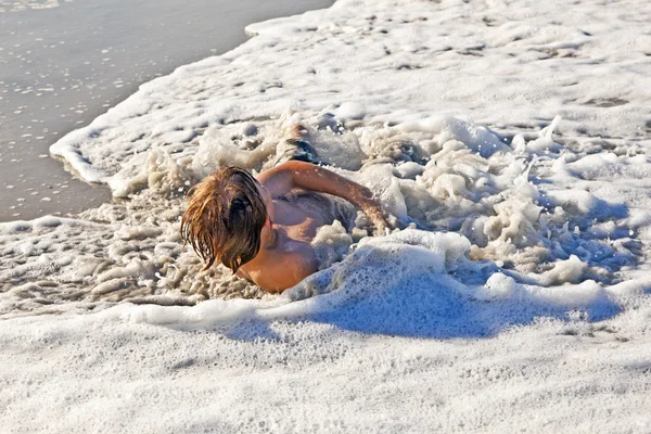 Niño tumbado en la playa y disfrutando del sol — Foto de Stock