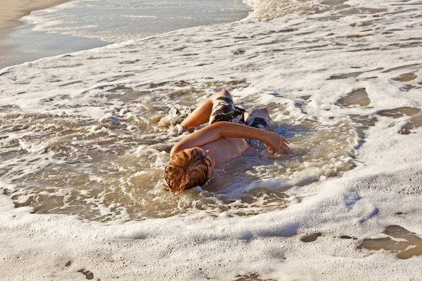 Menino deitado na praia e desfrutando do sol — Fotografia de Stock