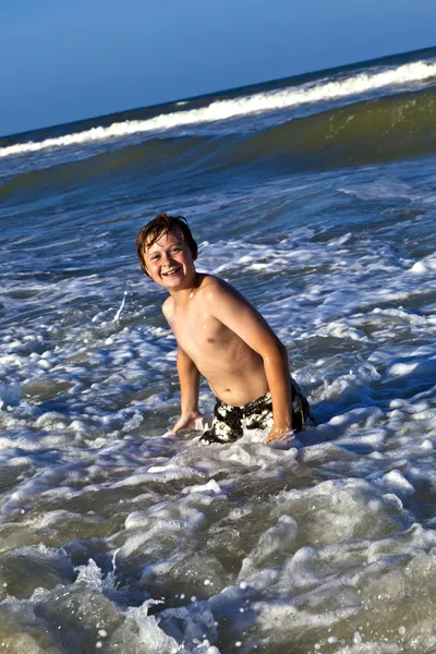 Ung pojke åtnjuter vågorna av det blå havet — Stockfoto
