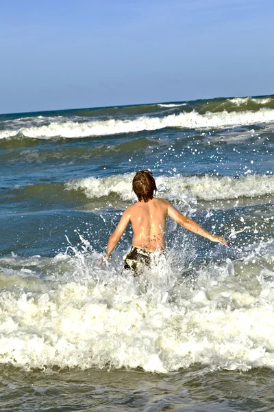 Fiatal fiú élvezi a kék tenger hullámai — Stock Fotó