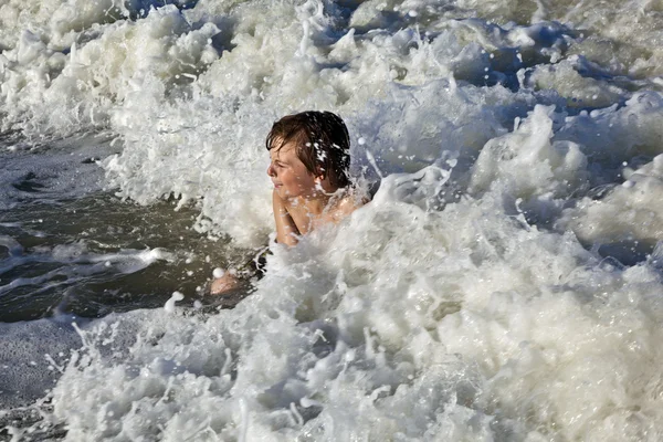 Joven niño disfruta de las olas del mar azul — Foto de Stock
