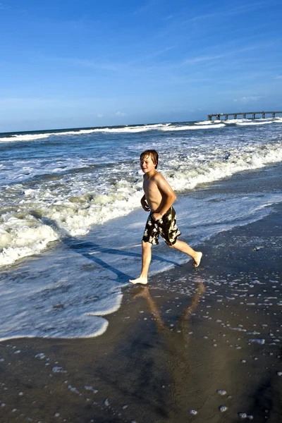 Мальчик наслаждается волнами синего моря — стоковое фото