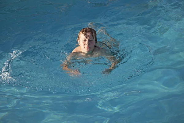 Fiú élvezi a medencében úszó — Stock Fotó