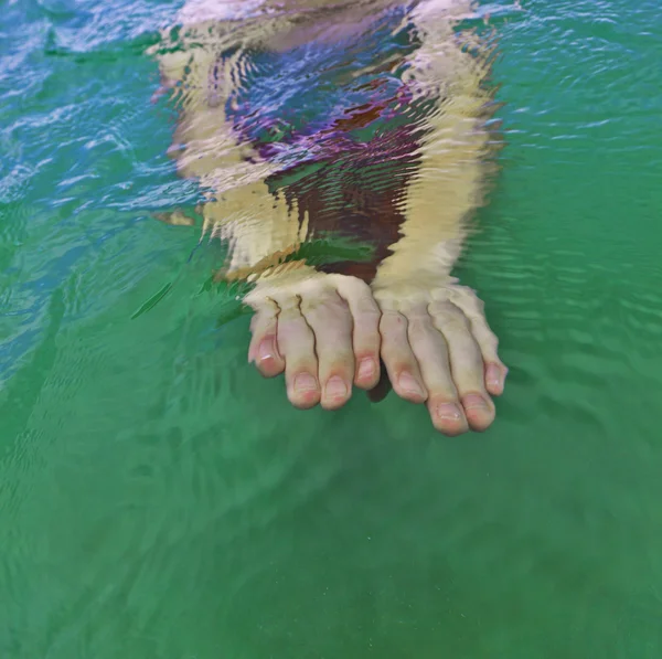 Hands of teen swimming in the ocean — Stock Photo, Image