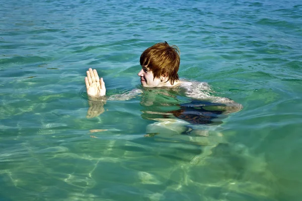 Rapaz ruivo imita um tubarão na bela diversão do mar — Fotografia de Stock