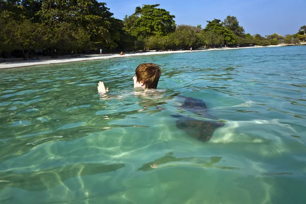 红头发男孩在美丽的海洋中模仿鲨鱼 — 图库照片