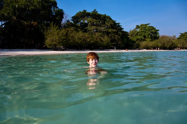 붉은 머리를 가진 소년 처럼 아름 다운 따뜻한 맑은 해변에서 수영 — 스톡 사진