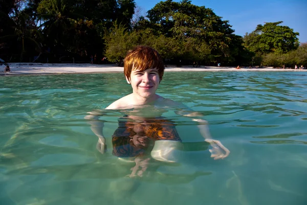 Vörös hajú fiú élvezi a kristálytiszta víz a tengerben — Stock Fotó