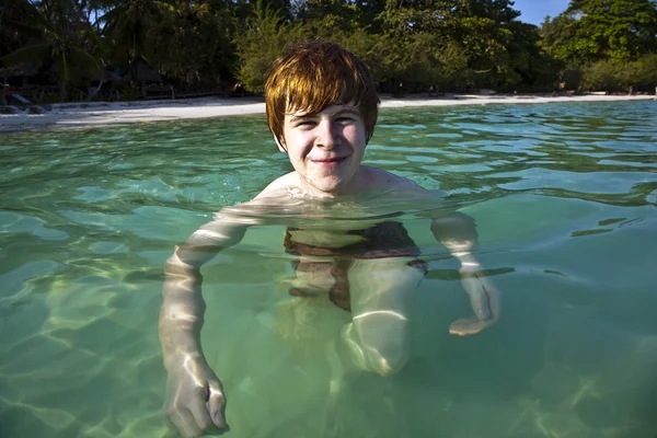 红头发的男孩喜欢水晶般清澈的水在海 — 图库照片
