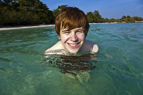Червоне волосся хлопчик насолоджується кришталево чистою водою в морі — стокове фото