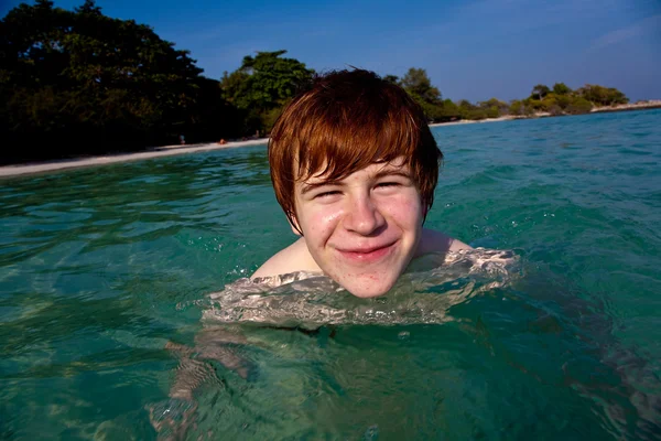 Червоне волосся хлопчик насолоджується кришталево чистою водою в морі — стокове фото