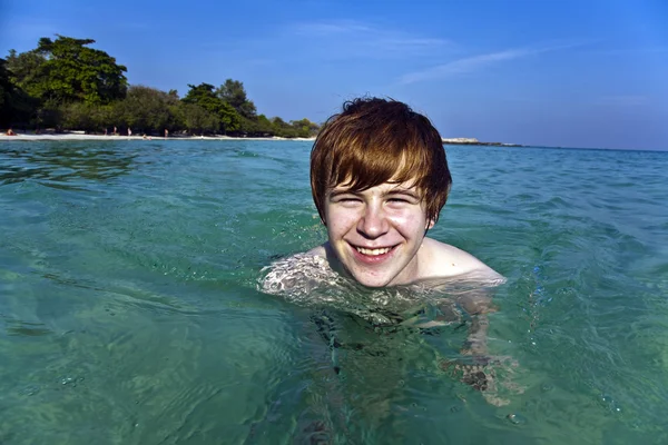 Red haired boy enjoys the crystal clear water in the sea — Stock Photo, Image