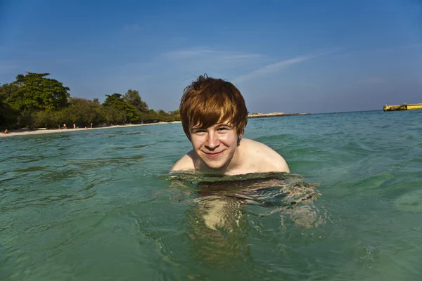 붉은 머리 소년이 즐긴다는 바다에 맑은 물을 — 스톡 사진