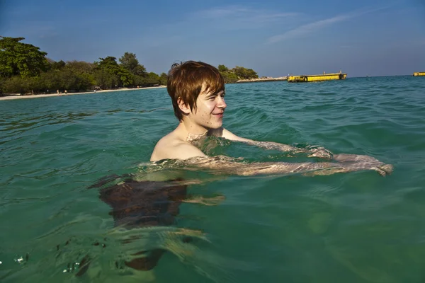 Czerwone włosy chłopak cieszy się krystalicznie czysta woda w morzu — Zdjęcie stockowe
