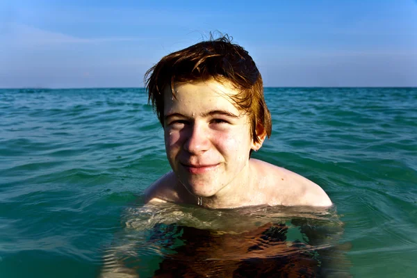 Niño con el pelo rojo está disfrutando del agua tibia clara en el beauti — Foto de Stock