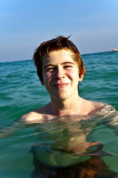 赤い髪の少年は、beauti で明らかに暖かい水を楽しんでいます。 — ストック写真