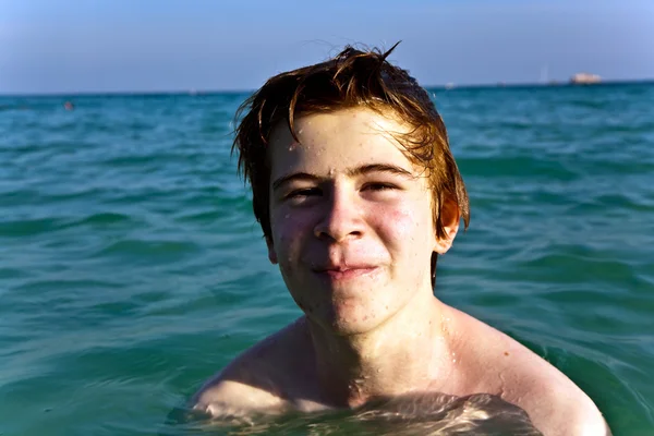 红头发的男孩享受在霏霏清晰温暖的水 — 图库照片