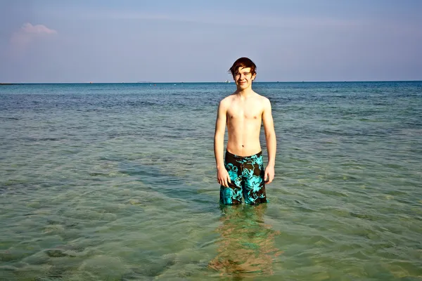 Kleiner Junge steht im schönen klaren Meer — Stockfoto