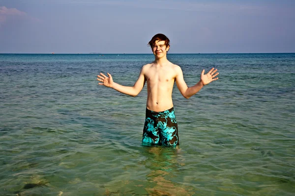 Jonge jongen is permanent in de prachtige heldere zee — Stockfoto