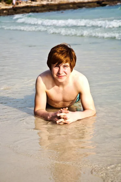 Boldog, vörös hajú fiú élvezi a gyönyörű tengerpart — Stock Fotó