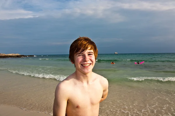 Šťastný chlapec s červenými vlasy se těší na krásnou pláž — Stock fotografie